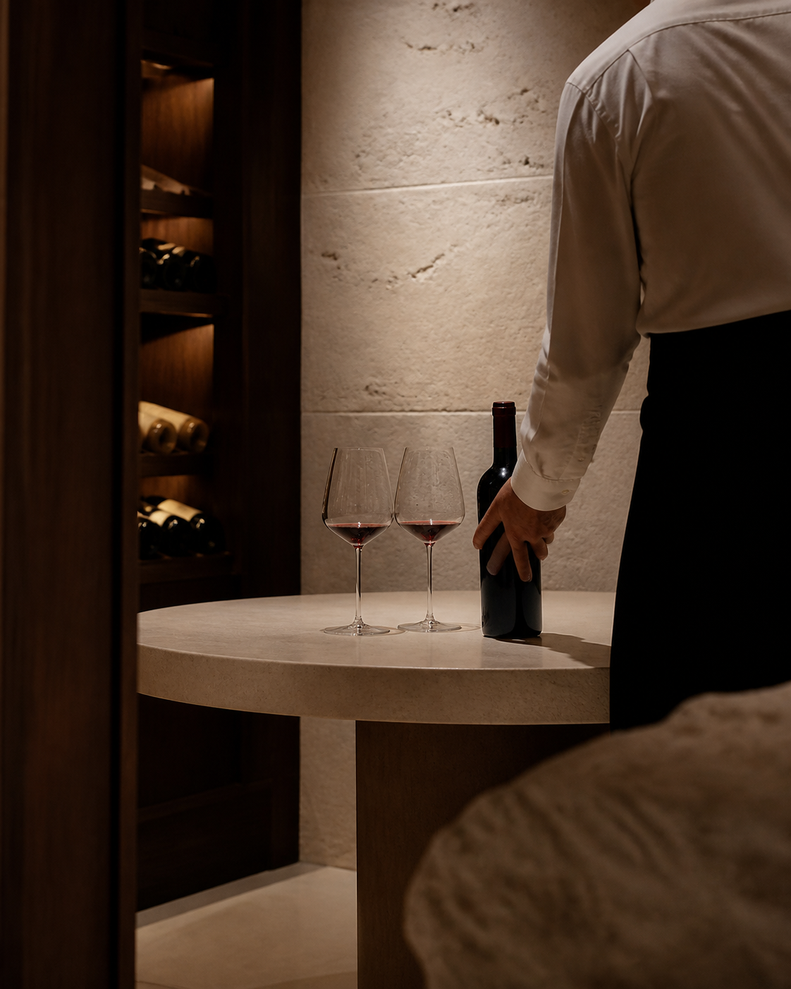 A sommelier preparing wine service in an intimate cellar